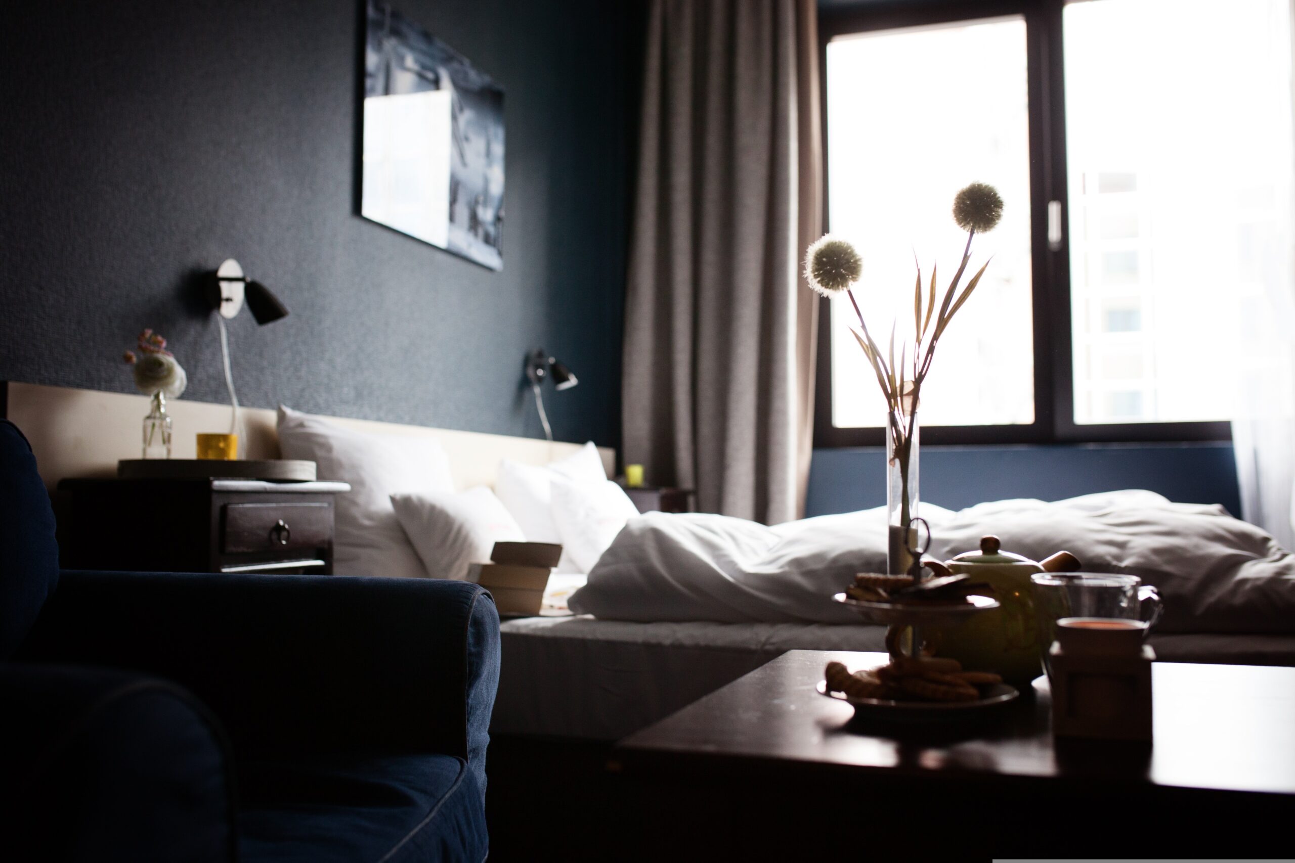 Cozy bedroom with a sunlit window and stylish decor.